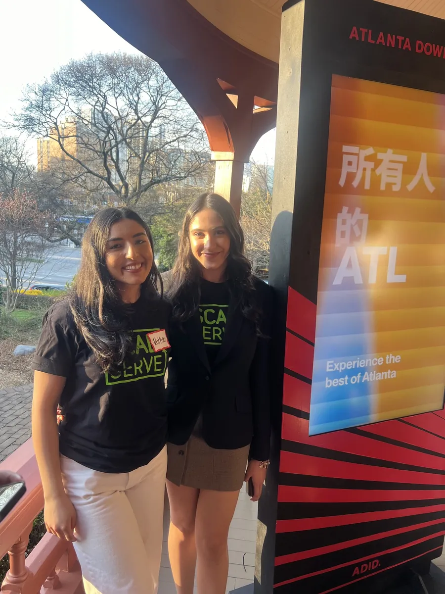 Two team members beside the kiosk