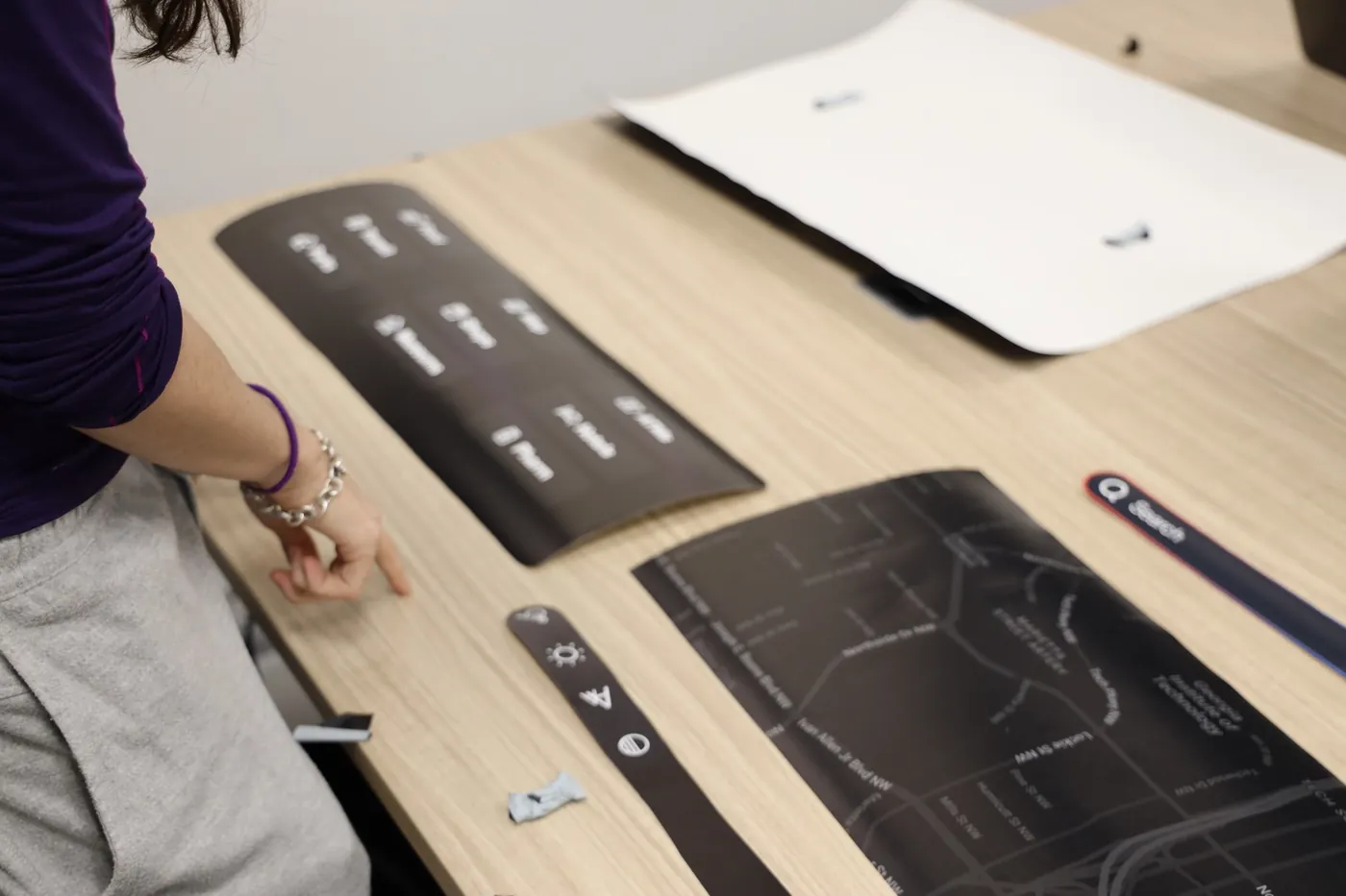 Paper prototype pieces of the kiosk interface laid out on a table
